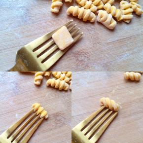 取一个吃饭用的叉子，将小方丁面片放在叉子上，用大拇指按住稍微用力顺着叉子搓下来，或者顺着叉子的左上方划搓过去，会做出两种造型不同的麻食（如图）。