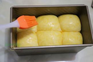 发酵好的面团取出，用刷子表面涂一层全蛋液，盖上吐司盖子。烤箱预热，165度，35分钟，烤吐司放入烤箱底层。