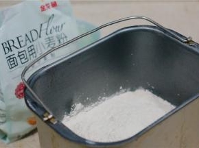 然后将金龙鱼面包用小麦粉称放至桶里面。再配入酵母及黑醋栗粉。