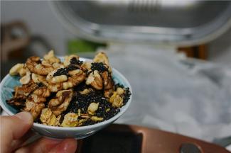 揉至油与面团完全融合之后，再加入核桃仁，黑芝麻及麦片。