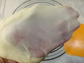 两手拿着面团，慢慢往两边扯，不要使劲扯，扯一点，再将面水平转一边，继续扯，慢慢将膜扯出来，不是就那么同一个方向使劲在那扯。看，能扯出薄而结实的膜。