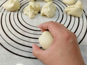 是检查膜，检查完，将面团继续放回大面团，再次收圆即可，然后分成45克一份，16份。取一个小面团，右手反C装握住面团，逆时针滚圆面团。