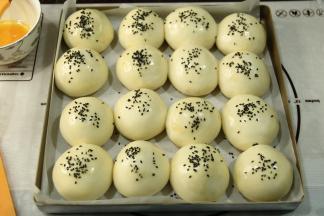 发酵完取出烤盘，预热烤箱上下185度。刷一层全蛋液，然后撒上黑芝麻。