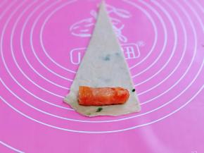 取一块饼胚，放上烤肠。(烤肠一切二)