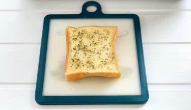 把蒜泥涂抹上并撒上欧芹碎。