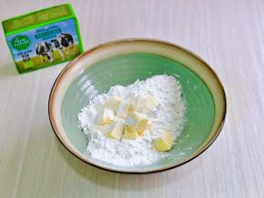 首先将面粉过细筛至大口器具中，再加入切小块室温软化过的黄油。