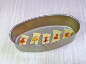 把多余的派皮用模具压了几块小熊抱杏仁的饼干，放入模具中。