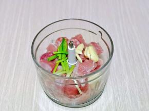 将肉块放入绞肉机中，再加入葱姜蒜。