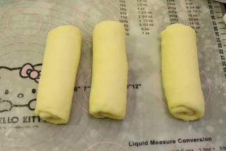 上下擀成椭圆型，从上往下卷翻面，盖上保鲜膜，松弛15分钟。