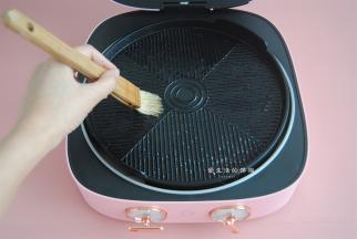 准备好锅具，我用的是大宇旋转烤盘，因为鸡翅有水分，所以会在烤盘上刷一层薄油，能起到防粘皮的作用。