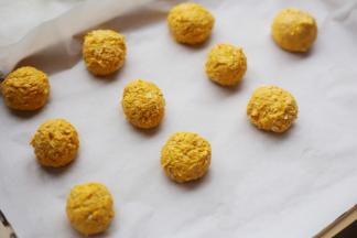 取适量南瓜泥，搓成小球，放在铺了烘焙纸的烤盘上。