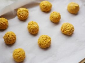 取适量南瓜泥，搓成小球，放在铺了烘焙纸的烤盘上。