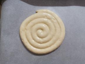 烤盘中铺好油纸，将裱花袋由里到外以画圈的方式，将面糊挤成一个8cm左右的圆形。按配方量我挤了8个