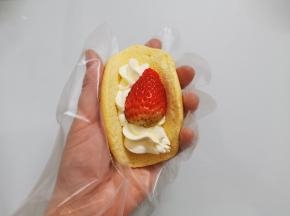 拿一个蛋糕饼，先挤一条，放上一个草莓