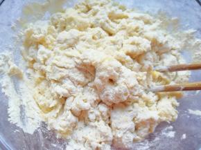 分次加入油条粉中，用筷子挑拌成絮状。