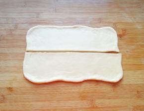 饧发好的面团不要揉，直接用擀面杖擀成长方形，从中间切开（如图）。