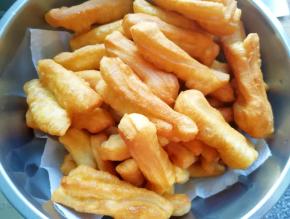 盆里铺上厨房用纸，放上炸好的小油条吸一吸多余的油。