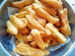 盆里铺上厨房用纸，放上炸好的小油条吸一吸多余的油。