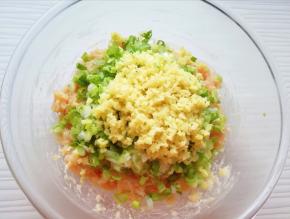 将切碎的葱姜碎放在肉馅上。