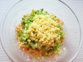 将切碎的葱姜碎放在肉馅上。