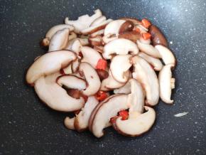 下入香菇翻炒至变软。