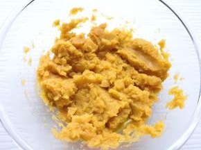 蒸熟的蜜红薯片从蒸锅里取出晾至温热，放进大一点的盆里，用勺子压成红薯泥。