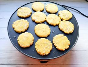 将搓好的糯米红薯小球用手掌压成饼状，粘上熟白芝麻，放在煎饼机上面，调至中火煎制。