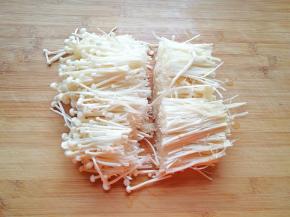 金针菇切去根部，用手撕开冲洗干净，从中间切开。