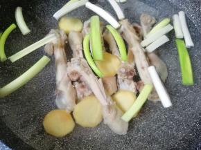 焯过水的鸡腿骨用凉水冲洗干净，放入锅中，加入没过鸡腿骨的水，放入葱姜一起烧开，中小火炖半个小时。
