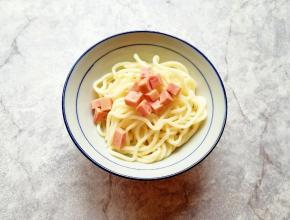 将面条盛在碗里，放上火腿肠。