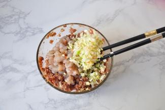 肉馅加入糖、料酒、酱油、胡椒粉搅匀上劲，将虾仁粗粗的切成大粒也放入其中。接下来，就是大葱饺子好吃的关键了。大葱我们要选择葱白，不要葱叶，葱结的部分也不要用，如果放进去会发苦。虽然叫大葱馅饺子，大葱也只是比平时当调味料时多一点，不要放太多，太多大葱会抢了肉和虾的香味，蒸好或煮好后，一股大葱的味道。所以说，我朋友说大葱饺子不好吃，肯定是放了太多大葱的原因。