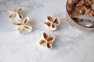 接下来，在四个周中再塞入一些肉馅。这样的四喜饺子吃起来口感更过瘾，外形也更饱满。