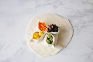 最后，分别在四个角塞入玉米，胡萝卜、木耳、豌豆，顺序您自已决定。然后将边角再捏一下。您在家做，可以换成这四种色彩的其它食材，都是可以的。