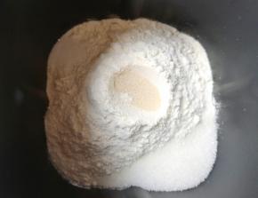 面包机桶内先打入一个鸡蛋，然后加入南瓜泥和水，再加入奶粉和高筋面粉，糖和盐对角放，面粉中间挖个小洞放入干酵母，用面粉盖上，选择“自动和面”10分钟。