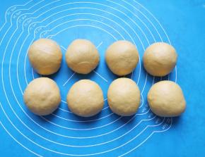 发酵好的面包面团拍打排气，分成8小份滚圆。