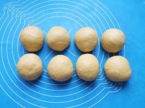 发酵好的面包面团拍打排气，分成8小份滚圆。