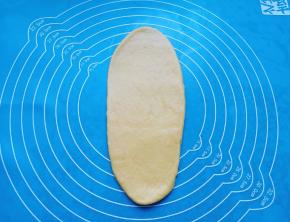 取一份面包面团擀成牛舌状。