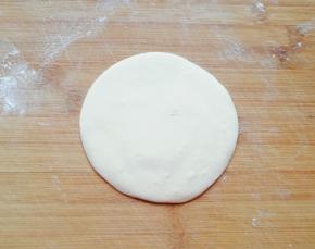 擀成中间稍厚边缘薄的包子皮。