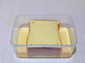 将蛋奶液倒入盒中，吐司的正反两面完全吸收蛋奶液，盖上盖子，放入冰箱冷藏室过夜，也可以装入食品袋中，总之让吐司片完全把蛋奶液吸收就可以。