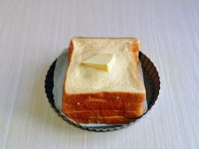 把浸泡好的吐司片放上，如下牙签，最后上面再放一块黄油。