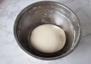 揉好的面团盖上湿布醒发半个小时，这样更利于饺子皮的擀制。