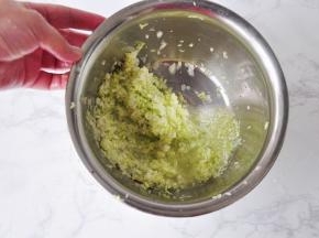 腌制五分钟后，白菜开始出水，您可以用手抓捏一下，帮助它快速出水。然后用手将白菜末团成小团，挤出水分。
