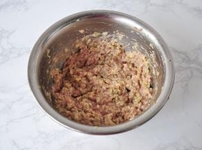 在搅打好的肉馅中加入少许盐、芝麻油，酱油拌匀，然后再放入白菜末拌匀。