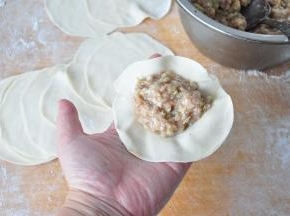 将馅料放在饺子皮中，包成您喜欢的饺子形状。