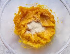 蒸熟的南瓜片从蒸锅里取出，放入盆里用勺子压成南瓜泥，晾至温热加入发酵粉搅拌均匀。