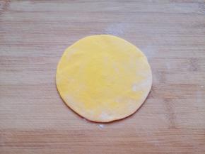 压扁，擀成中间稍厚边缘薄的包子皮。