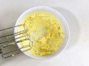 继续搅打至黄油蓬松发白。