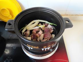 砂锅放油，油温升起放入腊肉和葱翻炒