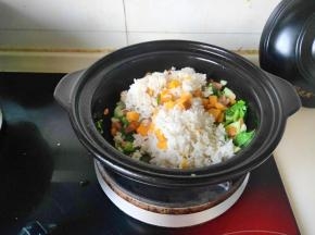 再将剩米饭倒入砂锅内翻炒打散米饭，持续以中火炒至米饭干松有香味溢出即可。