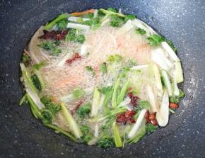 下入准备好的生姜、洋葱、大葱、香菜、胡萝卜、八角和丁香，小火炸8–10分钟左右。